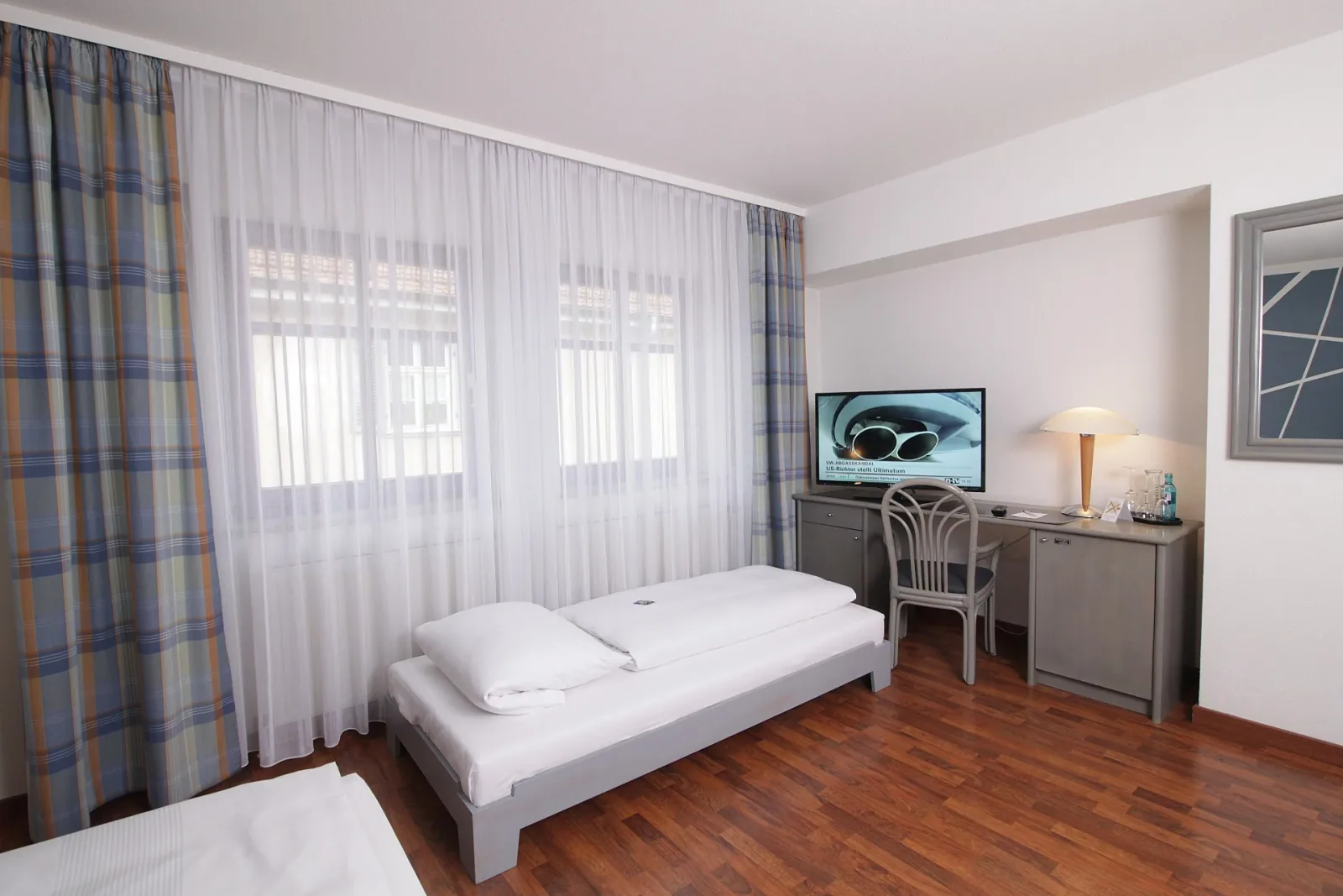 Gästezimmer mit Einzelbett, Schreibtisch und Fernseher im Art-Hotel Erlangen